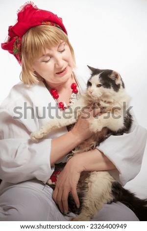 Portrait of a cheerful funny adult mature woman solokha. Female model in clothes of national ethnic Slavic style. A stylized Ukrainian, Belarusian or Russian woman poses in a comic photo shoot