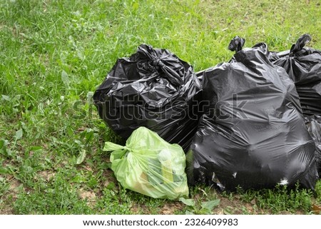 plastic bags with garbage lie on the grass, copy space