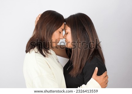 photograph of a female couple on a light photographic studio background.