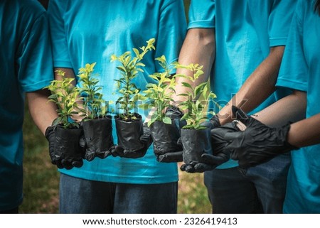 Group of people volunteering holding a sapling of a tree to be planted, which is a campaign to raise awareness of global warming. to volunteer and save the world concept. Royalty-Free Stock Photo #2326419413