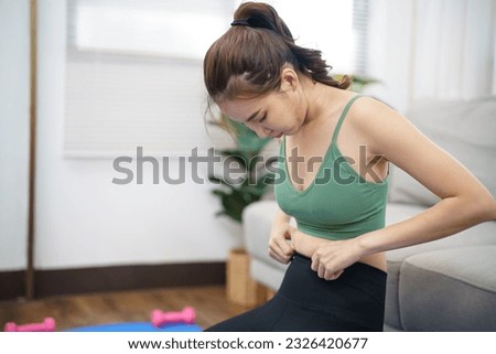 Asian woman with anorexia  with measuring tape feeling unhappy. Anorexia problem body perception and dysmorphia concept. Royalty-Free Stock Photo #2326420677
