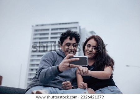 Photograph of a young couple looking attentively at a cell phone. Lifestyle concept, convenience and couples.