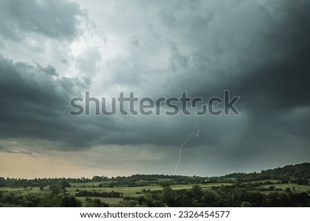 Storm clouds and lightning above the countryside Royalty-Free Stock Photo #2326454577
