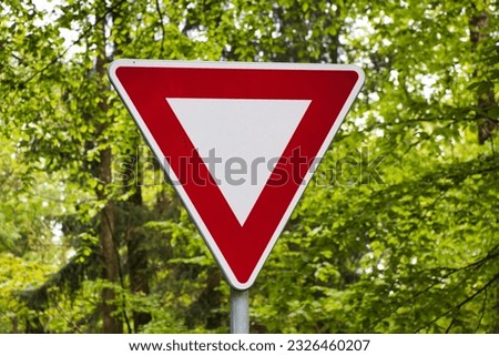 International traffic sign 'Yield sign' or 'Give way' in detail view with green background. Czech Republic.