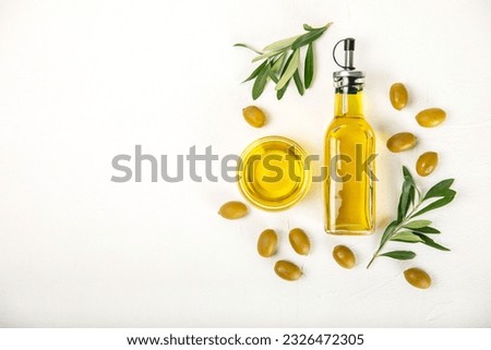 Olive oil in a bottle on a white texture background. Oil bottle with branches and fruits of olives. Place for text. copy space. cooking oil and salad dressing. Royalty-Free Stock Photo #2326472305