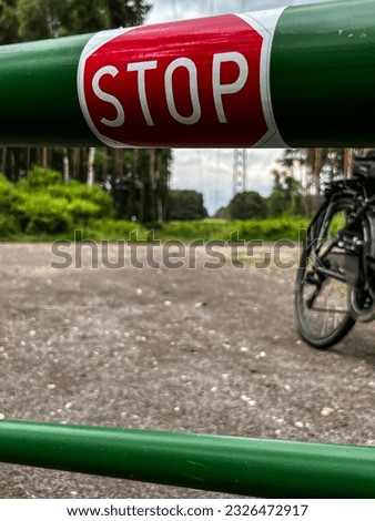 The inscription "stop" on the green barrier limiting the entrance to the forest.