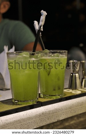 A closeup of an alcoholic cocktail on the table with a blurry background at a nightclub