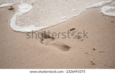 Footprint on the wet sand on the beach. Walking on the beach, human footprints.