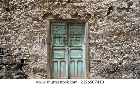 A century old house-cave wall with an old green wood door isolated in Güímar, Tenerife, Canary Islands, Spain 