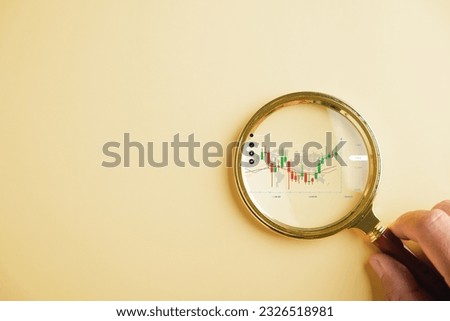 Magnifier glass examines the bar graph with an increasing arrow, emphasizing the importance of analyzing technical data in stock market charts. Business investment earning income concept.