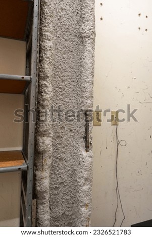 Photography of gray fireproofing insulation containing asbestos fibers. Focus on exposed steel area. Royalty-Free Stock Photo #2326521783