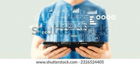 Micropayments theme with young man using a tablet computer Royalty-Free Stock Photo #2326524405