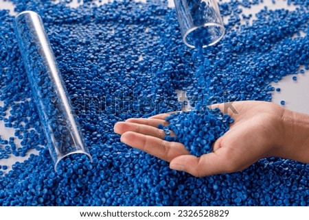 White plastic grain, plastic polymer granules,hand hold Polymer pellets, Raw materials for making water pipes, Plastics from petrochemicals and compound extrusion, resin from plant polyethylene. Royalty-Free Stock Photo #2326528829