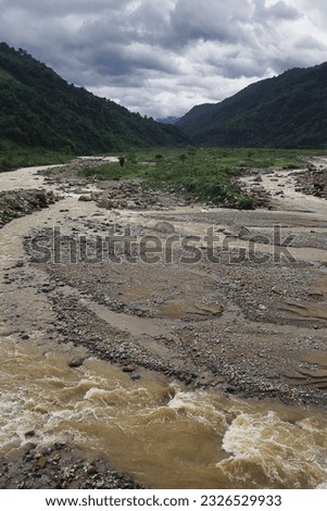 beautiful river valley, flowing stream, forest and himalaya foothills of terai - dooars region. birds eye view of flowing balason river in monsoon season at dudhia, darjeeling in west bengal, india Royalty-Free Stock Photo #2326529933