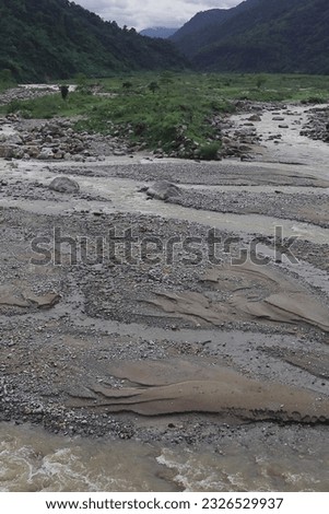 beautiful river valley, flowing stream, forest and himalaya foothills of terai - dooars region. birds eye view of flowing balason river in monsoon season at dudhia, darjeeling in west bengal, india Royalty-Free Stock Photo #2326529937