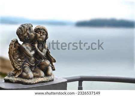 two angels kissing sculpture on the wall. High quality photo
