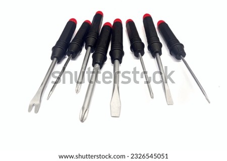 Screwdrivers set on isolated white background. Various different type and size of screwdrivers with black and red handle. Philips crossedhead, flattedhead and spanner screwdrivers