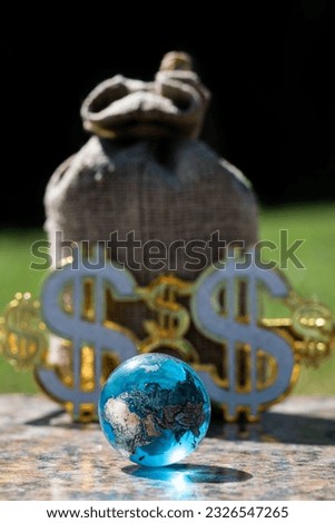 Symbolic glass globe and shining symbols of the American dollar