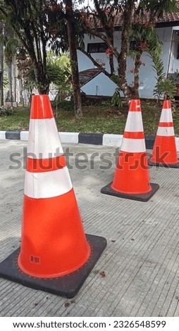 Red cone sign lying on the road
