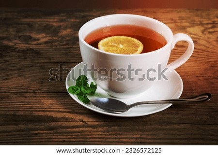 Cup of tea with mint leaf and lemon slice on old wooden desk, empty space for text Royalty-Free Stock Photo #2326572125