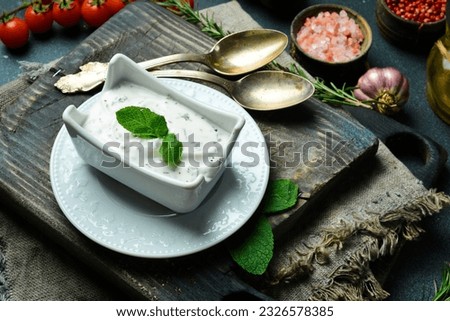 Sour cream sauce with dill and garlic in a white bowl. Traditional Tzatziki dip, made with yogurt or sour cream. Free space for text. Royalty-Free Stock Photo #2326578385