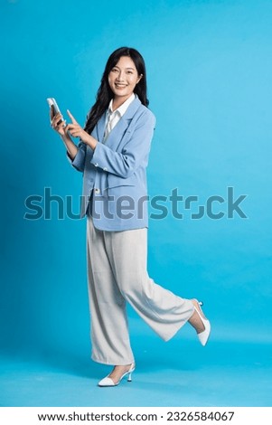 Asian young businesswoman portrait on blue background Royalty-Free Stock Photo #2326584067