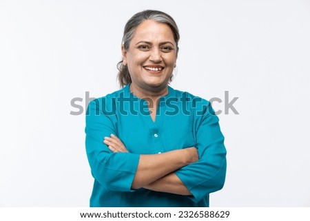 Portrait of confident mature woman wearing formalwear with arms crossed standing against white background Royalty-Free Stock Photo #2326588629