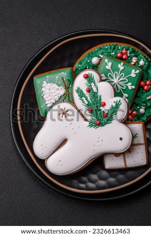 Beautiful Christmas or New Year colorful homemade gingerbread cookies on a ceramic plate on a dark concrete background