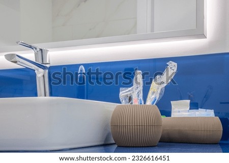 Interior of apartment standard modern bathroom with toilet bowl and glass shower cabin