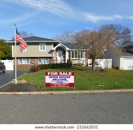 American flag pole Real Estate For Sale Open House Welcome sign curb of suburban high ranch home autumn day residential neighborhood blue sky clouds USA