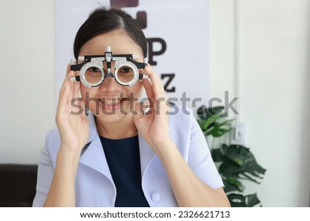 Female ophthalmologist wearing eyeglasses inside clinic, eye doctor wearing trial frame in eyeglasses shop, Ophthalmologist wearing trial frame in eyeglass clinic