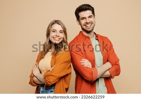 Side view young smiling happy fun cool couple two friends family man woman wear casual clothes hold hands crossed folded together isolated on pastel plain light beige color background studio portrait Royalty-Free Stock Photo #2326622259