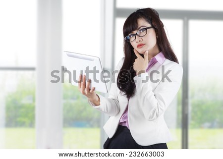 Thoughtful businesswoman holding digital tablet. shoot in office