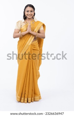 Smiling south indian woman in sari greeting with prayer pose Royalty-Free Stock Photo #2326636947
