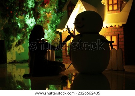 Silhouette of woman and snowman in front of christmas decorations. sad christmas concept