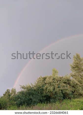 Full rainbow after rain against a the sky