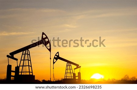 Silhouette of Oil pump. Industrial machine for petroleum on background of sunset