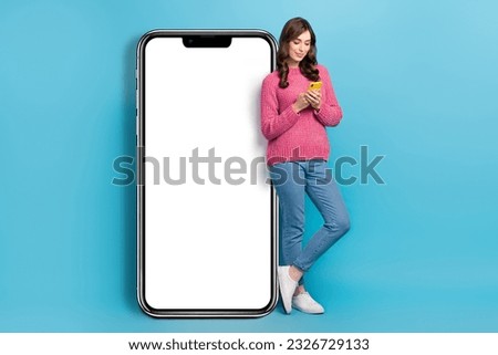 Full length size photo of modern gadgets user woman hold smartphone near huge display menu dating advert web panel isolated on blue color background