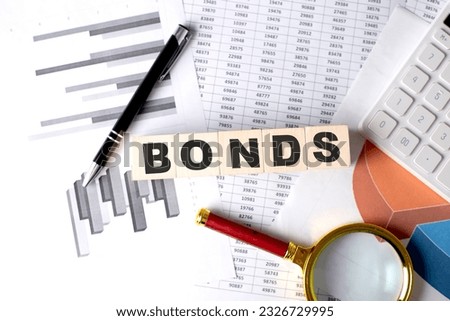 BONDS text on a wooden block on graph background with pen and magnifier Royalty-Free Stock Photo #2326729995