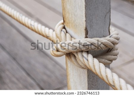 fence pole tied with rope, rope knot on fence of wooden bridge Royalty-Free Stock Photo #2326746113