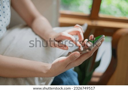 Close up of Young Asian woman student or freelancer 's hand enjoy playing social media, chatting, online shopping watching internet platform, play game by smart phone or mobile phone. Weekend activity Royalty-Free Stock Photo #2326749517