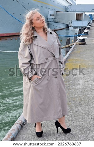 Woman on cruise wearing light long coat glamour beautiful luxury style cruise ship beautiful blonde model outside outdoors photoshot stylish luxury style photo in Rotterdam