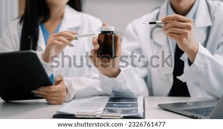 Pharmacists or doctors study information about tablets in the operating room in the evening.