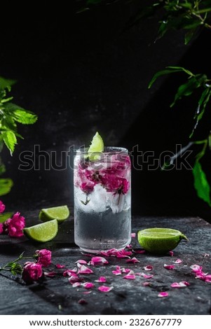Cocktail with rose and lime in a glass