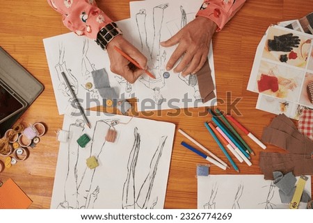 Fashion designer coloring sketches when working on collection for new season