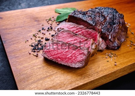 Barbecue dry aged wagyu rib-eye beef steaks with herb and black salt served as close-up on a modern design wooden board with copy space  Royalty-Free Stock Photo #2326778443