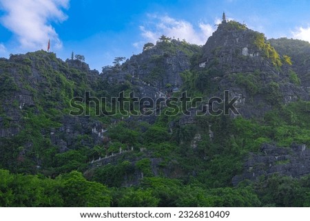 Dragon Mountain in Ninh Binh Hanoi Vietnam with over 500 zigzag steps to climb to the top with magnificent views of a big dragon on the mountain peak and a small temple 