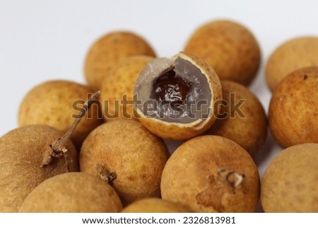 Longan fruit with flesh, seed, and peel visible, isolated on white background