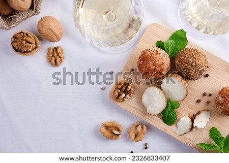 Belper knoll cheese with walnuts and mint and glasses of white wine. Space for text. Top view Royalty-Free Stock Photo #2326833407