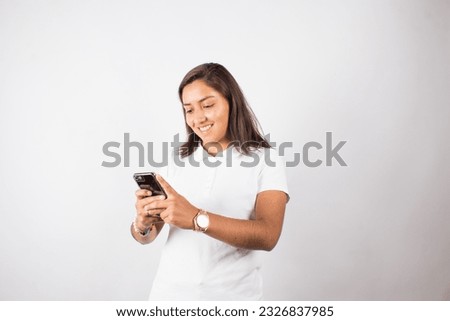 photograph of latina woman using cell phone on a photo studio background. Concept of people and technology.